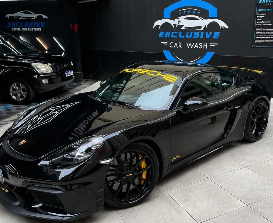 Porsche preto fotografado em ângulo dentro do estúdio da Exclusive Car