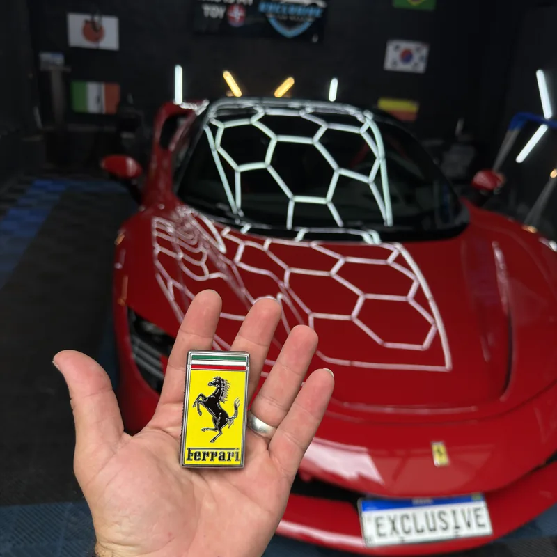 Chave Ferrari diante de veículo vermelho na Exclusive Car