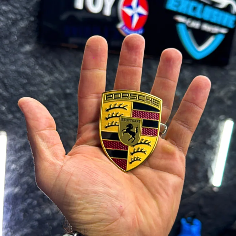Emblema Porsche em primeiro plano na Exclusive Car